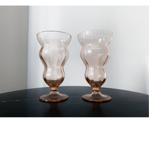Vintage wavy glass goblet. Color is peachy blush. Shop drinkware. Hogan Parker is a contemporary luxury online shop for books, gifts, vintage wares, soap, jewelry, home decor, cookware, kitchenware, and more.